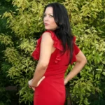 Christa Campbell net worth 2026 — actress and film producer posing in red dress outdoors