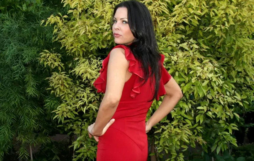 Christa Campbell net worth 2026 — actress and film producer posing in red dress outdoors