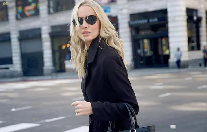 Helena Mattsson net worth - blonde actress in black coat carrying a handbag while crossing a city street
