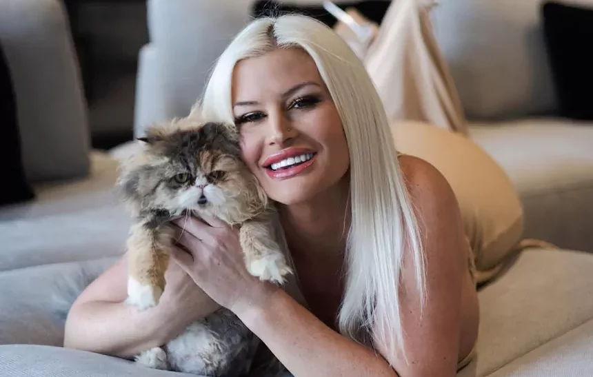 Julie Cash net worth 2026 - smiling with her Persian cat at home