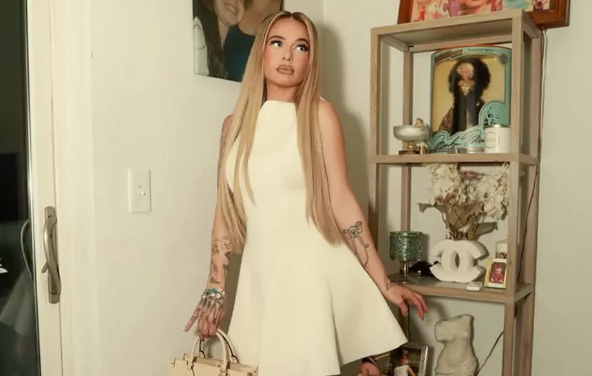 MariahLynn posing in a white dress at home with tattoos visible, representing her lifestyle and MariahLynn net worth story