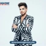 Adam Lambert in a black-and-white zebra-print suit, arms crossed, on a white background