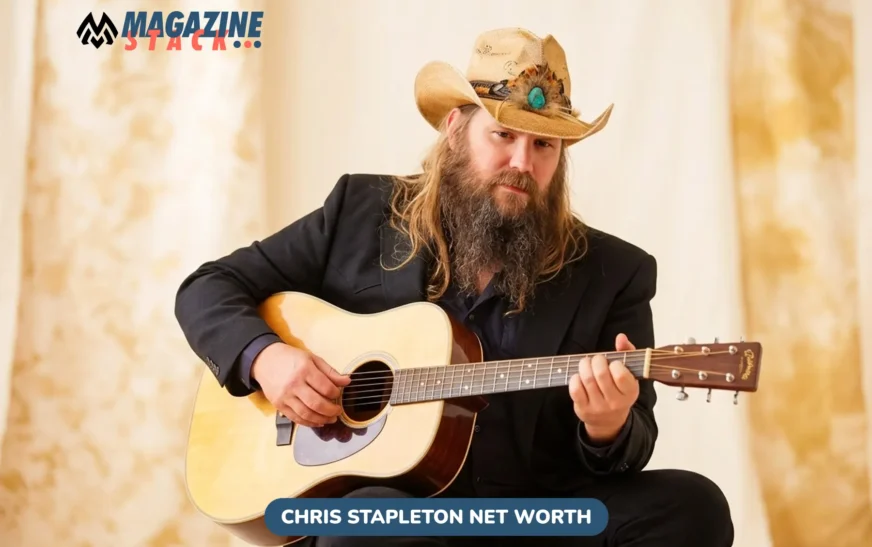 Chris Stapleton net worth photo: musician playing acoustic guitar in straw hat