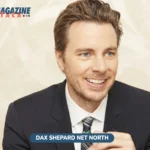 Dax Shepard net worth 2026 photo, smiling in navy suit and plaid tie