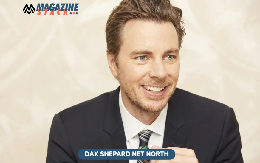 Dax Shepard net worth 2026 photo, smiling in navy suit and plaid tie